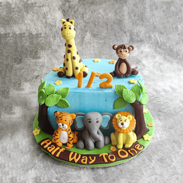 Delicious Cake Design - A cute animal themed 1st birthday cake with hand  crafted sugar figures of an elephant, lion and monkey sitting in front of a  large fondant one on top